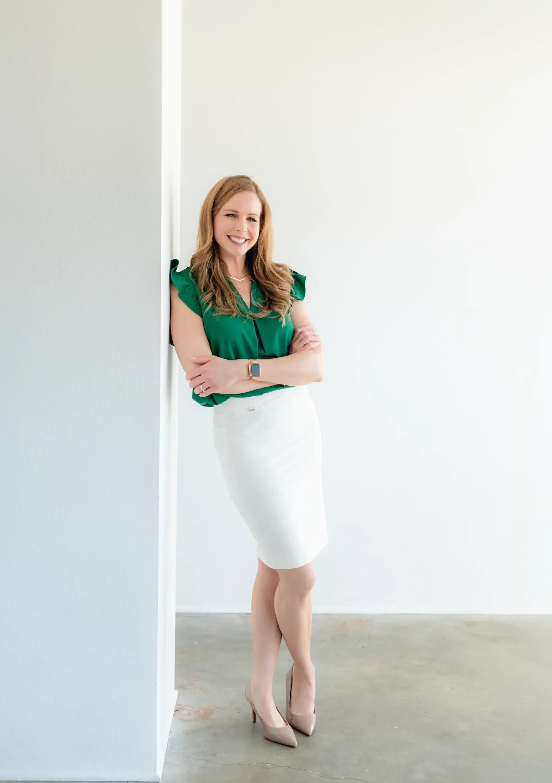 Heather standing in a green top and white skirt represents web design, SEO and marketing